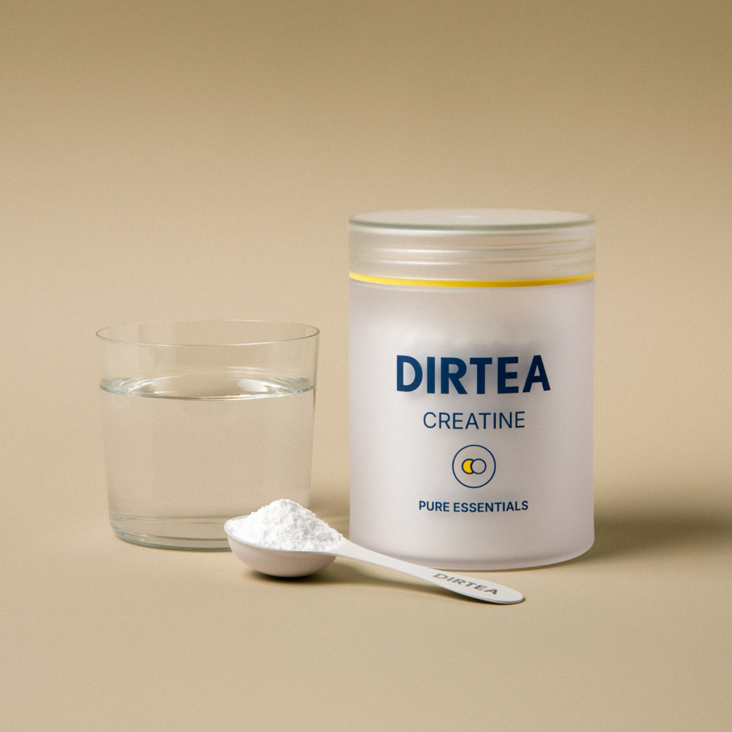 Container of DIRTEA Creatine with a glass of water and a spoonful of powder on a beige background